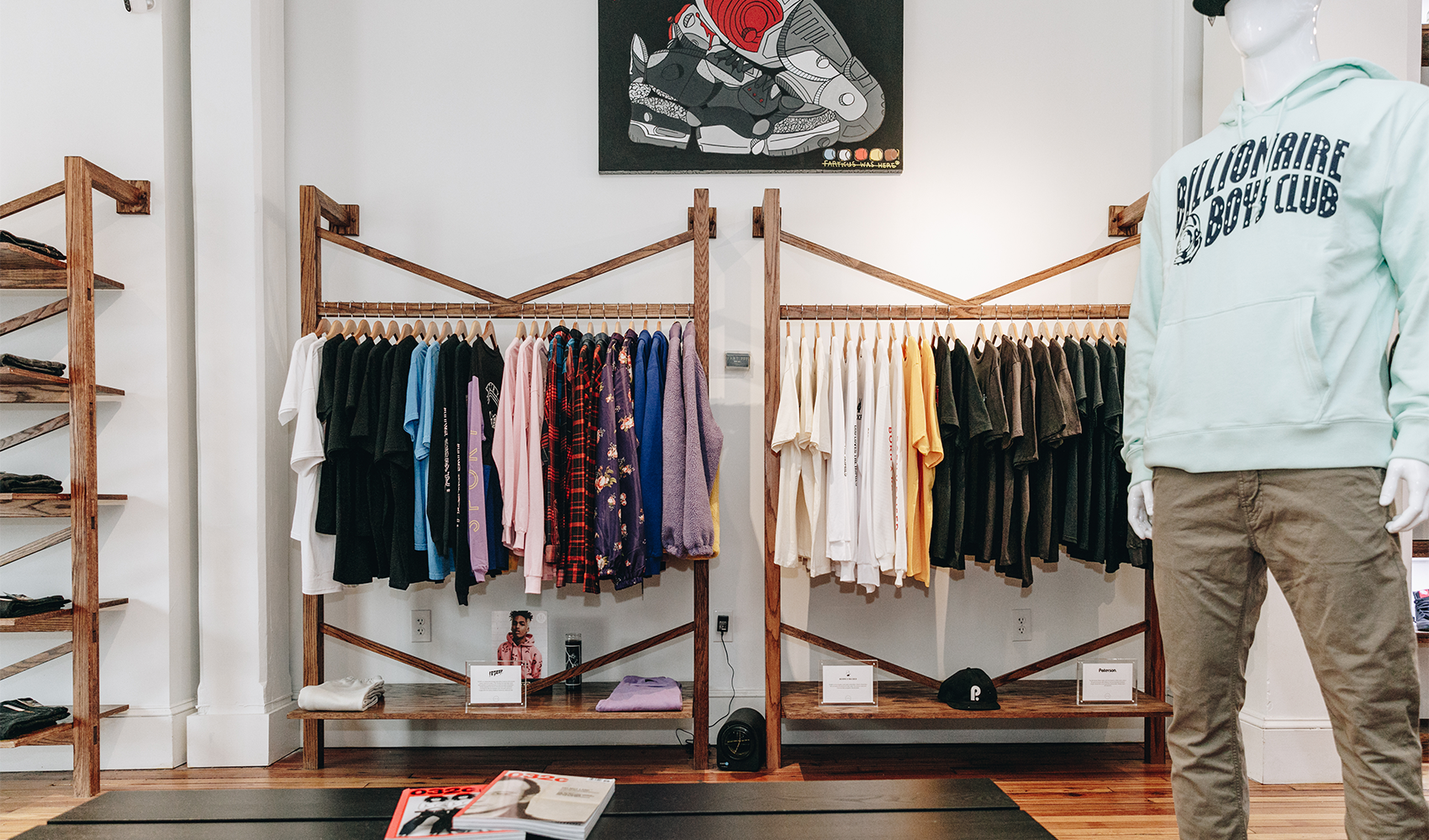 Men’s streetwear store display with colorful shirts, graphic hoodie, and sneaker artwork