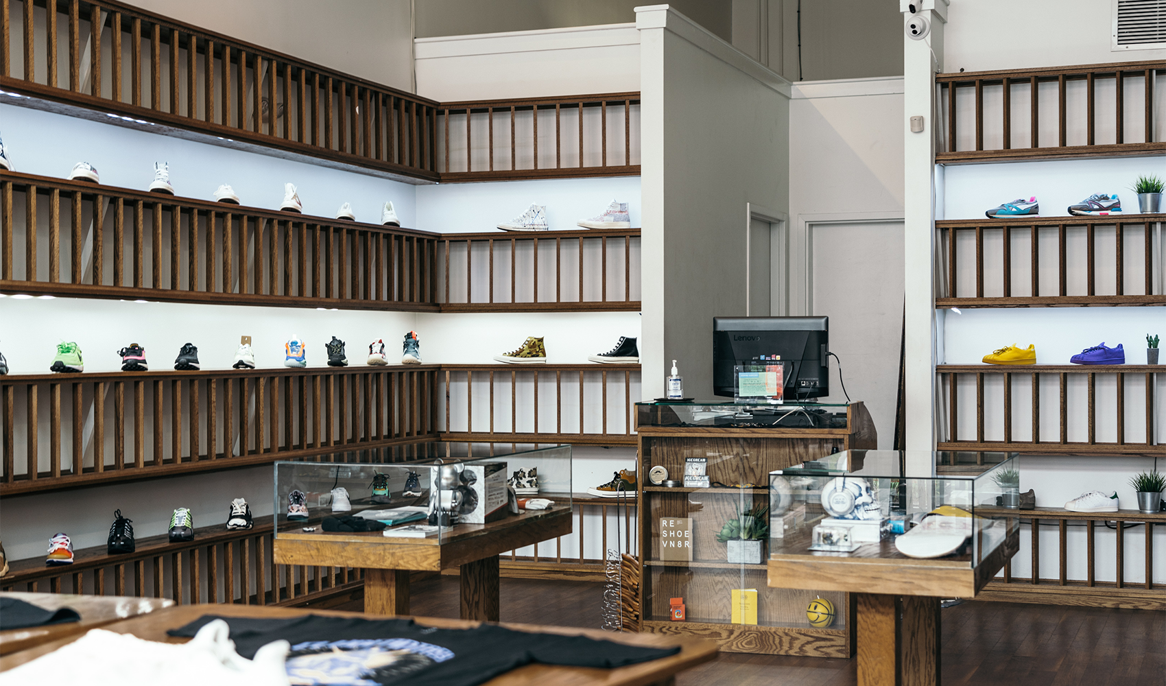 Modern sneaker store interior with wooden shelves displaying various men's streetwear shoes