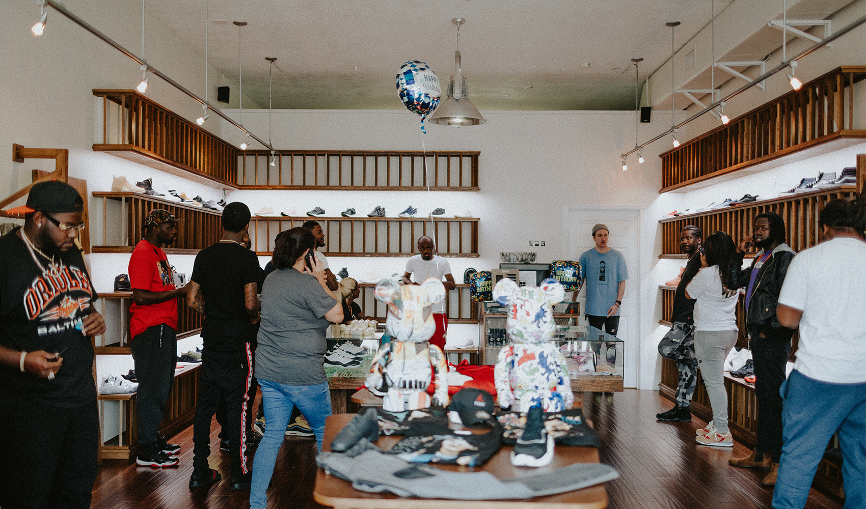 People shopping in a modern streetwear and sneaker store, shelves filled with shoes, apparel display.