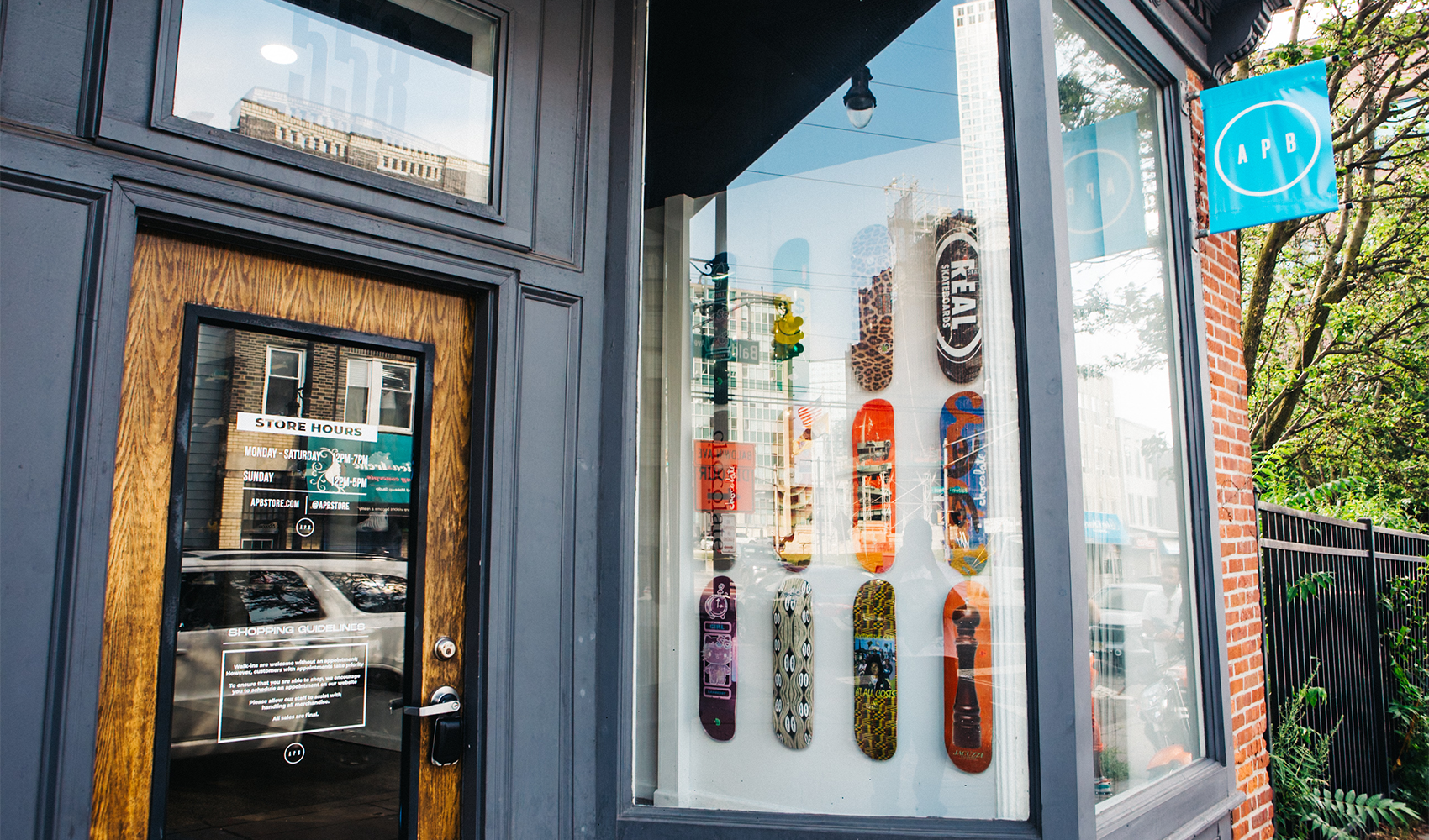 Streetwear store exterior with skateboard decks displayed in window, modern brick facade