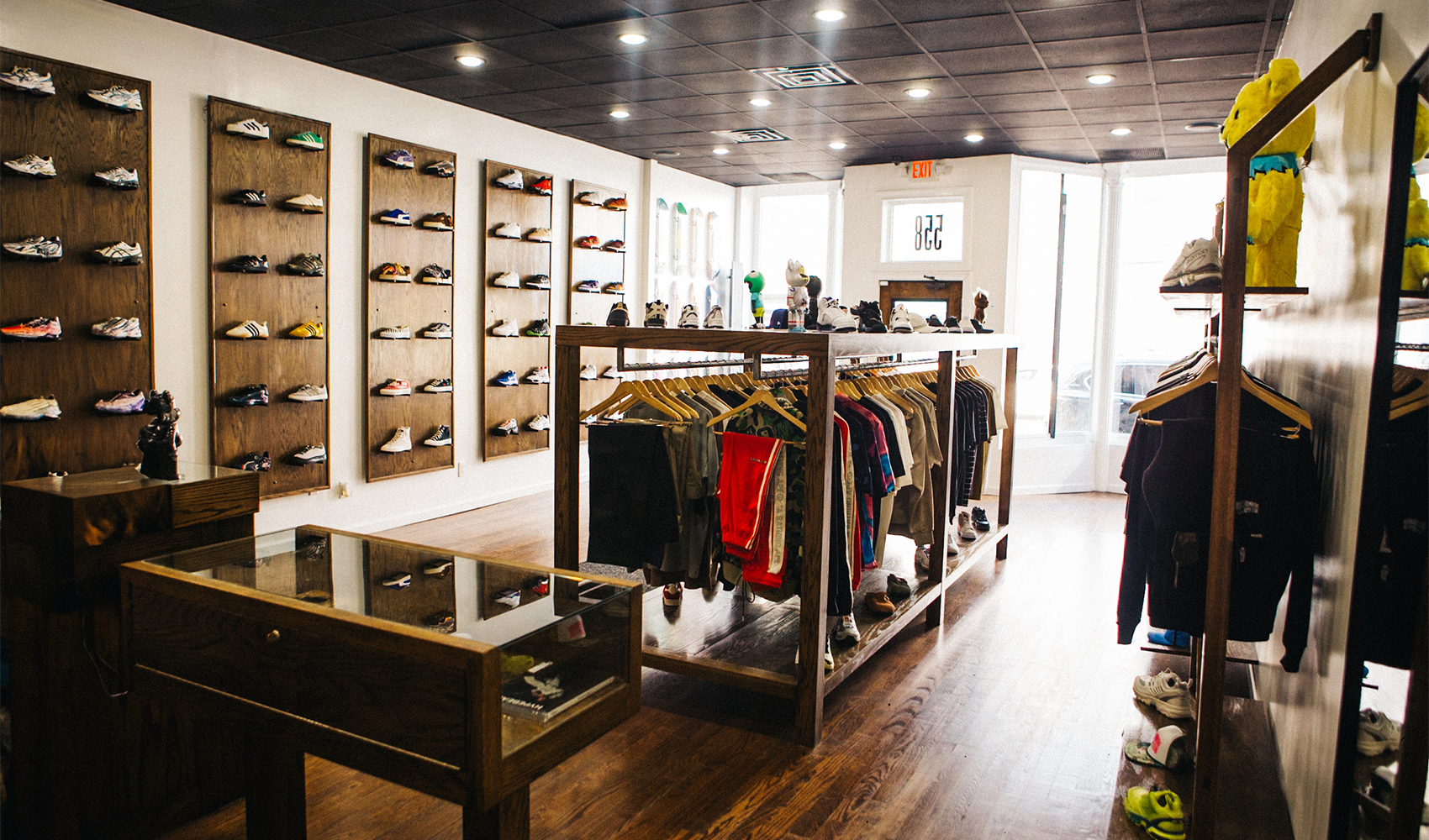 Modern streetwear store interior with sneakers on display walls and men's apparel on racks