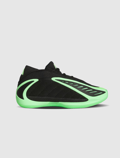 Black and neon green low-top sneaker with sculpted details on a plain background