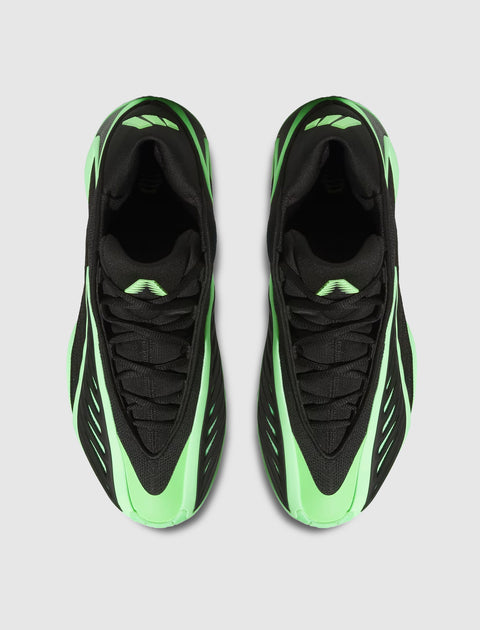 Top view of black and neon green men's streetwear sneakers on a light gray background