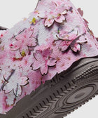 Closeup of sneaker with pink cherry blossom petal overlays and textured sole