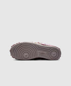 Close-up of the outsole of a grey and pink sneaker with floral details, streetwear shoe