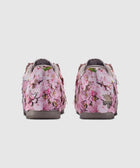 Back view of sneakers with pink cherry blossom floral print and textured petal details
