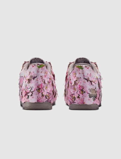 Back view of sneakers with pink cherry blossom floral print and textured petal details