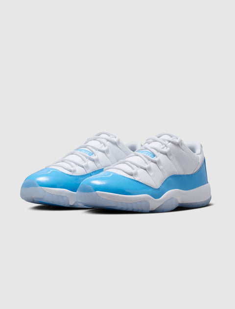 White and blue low-top sneakers with patent leather toe on a neutral background