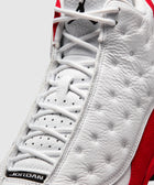 Close-up of white and red leather sneaker with perforated details and laces