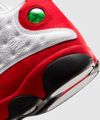 Close-up of red, white, and black sneaker heel with green holographic detail, textured sole