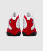 Rear view of white and red high-top sneakers with black soles on a plain background