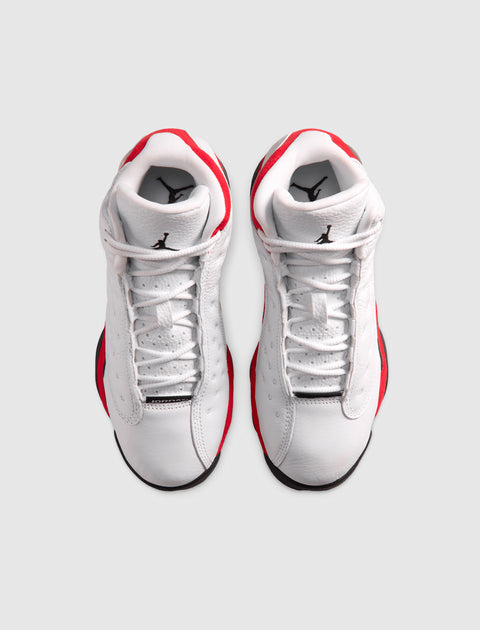 Pair of white and red high-top sneakers with black logo, top view on plain background