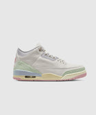 White leather sneaker with pastel green, yellow, and pink accents on a light background