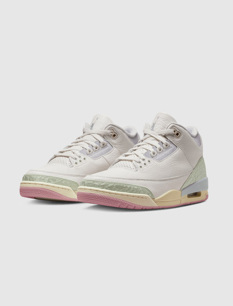 White leather sneakers with pastel green and pink accents, visible air sole, stylish streetwear shoes