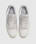 Top view of white Nike Air Jordan 3 sneakers with pastel accents on a light background