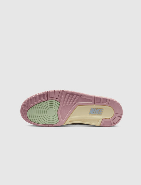 Colorful sneaker outsole with pink, cream, and green accents, showing Nike logo