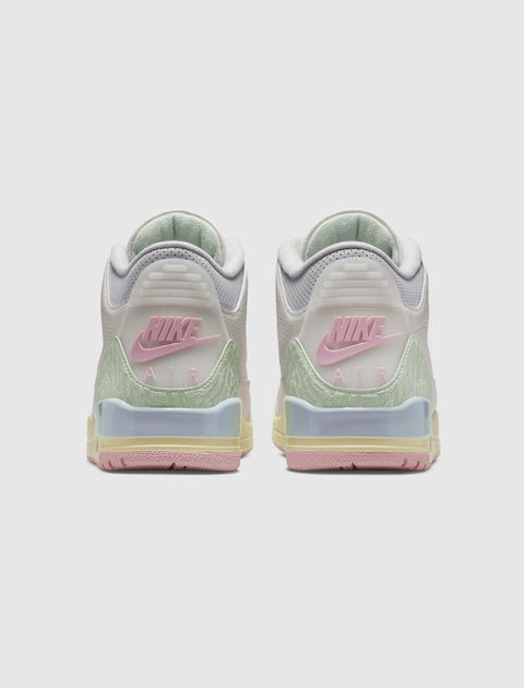 Back view of pastel Nike Air sneakers with pink, green, and yellow accents on a white background.