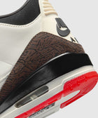 Close-up of Nike Air sneaker heel with brown textured panel, visible air sole, and red outsole