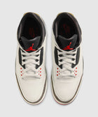 White and black men's sneakers with red accents, viewed from above on a neutral background