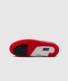 Sole view of a sneaker with red, black, and white color blocks and visible Nike logo