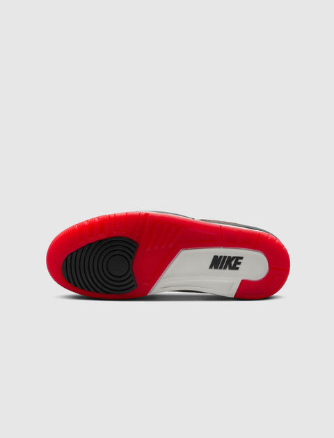 Sole view of a sneaker with red, black, and white color blocks and visible Nike logo