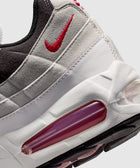Close-up of white and grey sneaker with red Swoosh logo and visible air sole unit