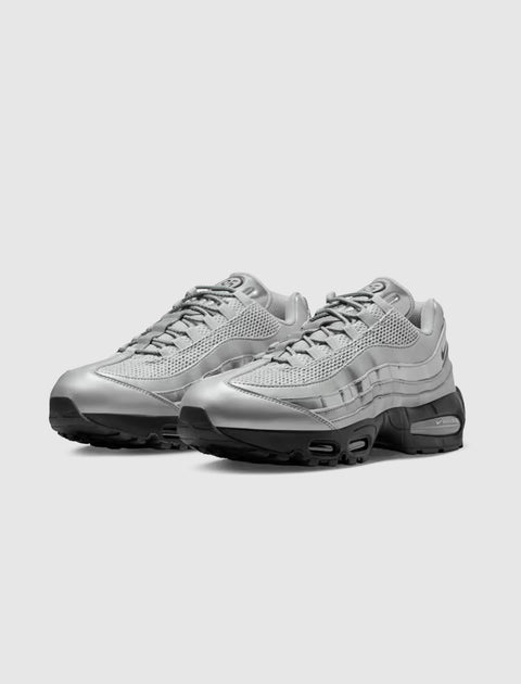 Pair of silver athletic sneakers with mesh and leather upper on a white background