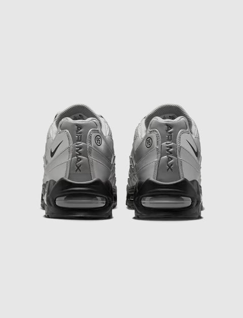 Back view of silver and black Air Max sneakers with visible air cushion soles on white background.