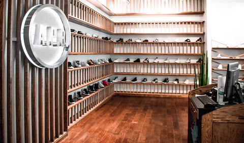 Modern sneaker store interior with wooden shelves displaying men's streetwear shoes