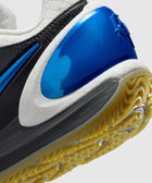 Close-up of a sneaker heel with blue, black, and white details and textured yellow outsole