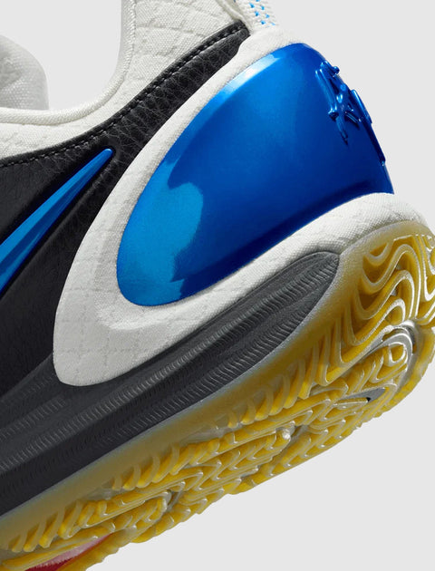 Close-up of a sneaker heel with blue, black, and white details and textured yellow outsole