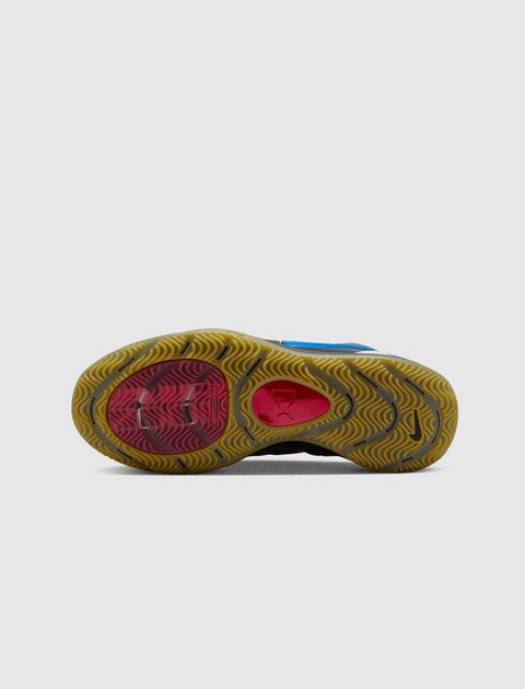 Outsole view of a sneaker with gum sole, red accents, blue upper, and traction pattern