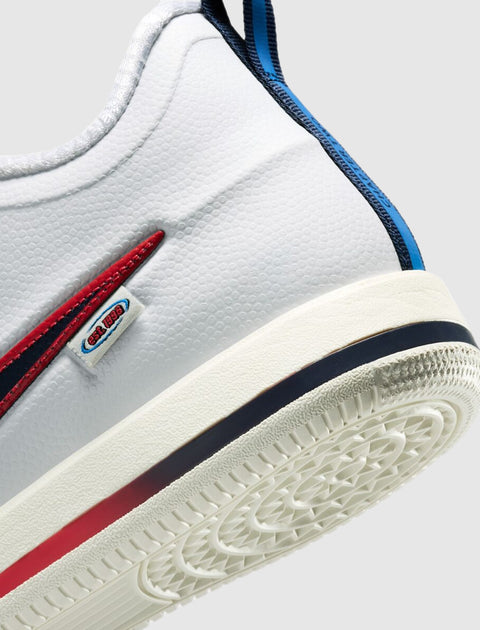 Close-up of white sneaker heel with textured sole, red and blue stripe accents