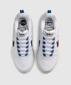 White men’s sneakers with red swoosh, blue lace eyelets, and graphic insoles, top view