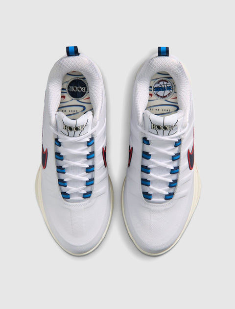 White men’s sneakers with red swoosh, blue lace eyelets, and graphic insoles, top view