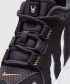 Close-up of black and white sneaker with gold stitching and textured laces