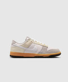 Low-top grey and beige suede sneaker with white swoosh and gum sole on white background