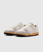 Pair of low-top sneakers with white, beige, and grey panels and gum rubber soles