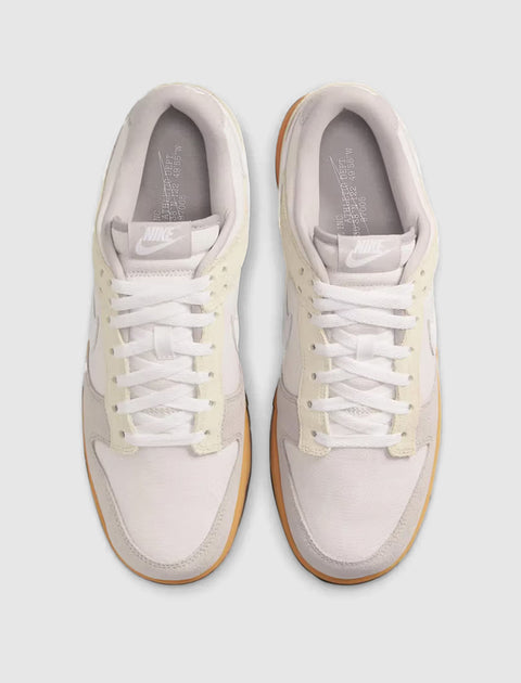 Top view of grey and white low-top sneakers with gum soles on a light background