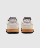 Back view of grey and white low-top sneakers with gum soles on white background