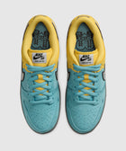 Top view of yellow and turquoise Nike SB Dunk Low Pro sneakers with black swoosh logo