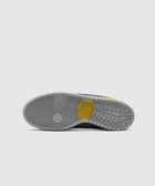 Grey and yellow sneaker outsole with circular tread pattern on white background
