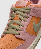 Close-up of suede sneaker with pink, orange, and olive green accents and laces