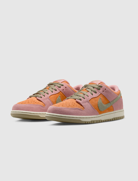 Pink and orange suede low-top sneakers with olive green laces and Swoosh logo on white background