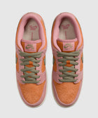 Top view of two low-top sneakers with orange suede toes, pink trim, and olive green laces.