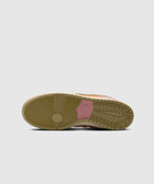 Close-up of gum sole with pink Nike SB branding on a sneaker, isolated on grey background