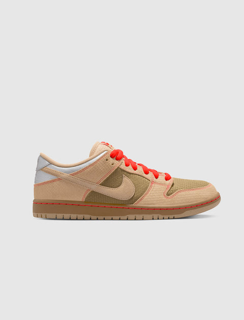 Beige and olive green low-top sneaker with red laces and textured panels on white background