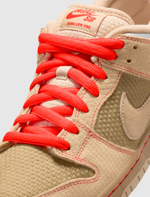 Close-up of tan Nike SB Dunk Low Pro sneaker with woven texture and bright red laces