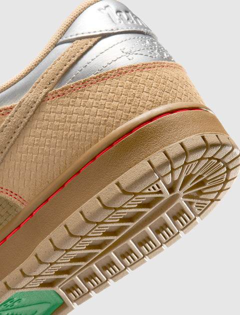 Close-up of beige and silver sneaker heel with textured upper, red stitching, and detailed sole