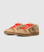 Beige and olive low-top sneakers with bright orange laces on a light background
